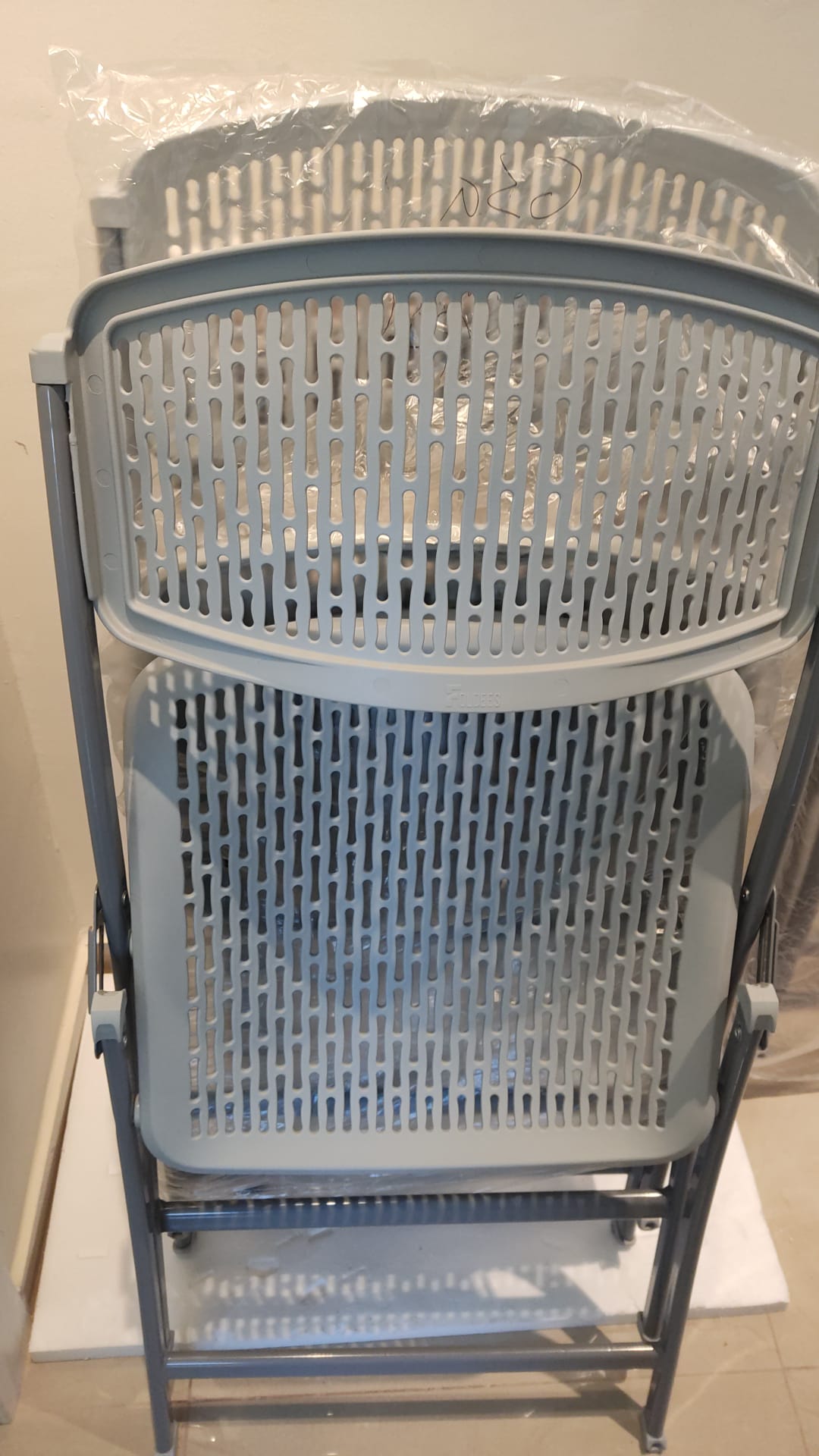 grey folding chairs with slight defect on plastic - The Jerusalem Market